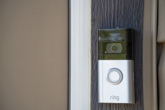 Close-up of a Ring video doorbell mounted on a residential front door.