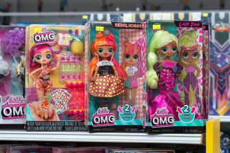 Four L.O.L. Surprise! O.M.G. dolls in colorful packaging on a store shelf.