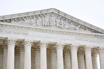 Exterior of the U.S. Supreme Court building featuring tall Corinthian columns and a sculpted pediment with figures, bearing the inscription Equal Justice Under Law.