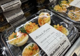 Deviled eggs in a clear plastic container with a Bristol Farms label on a grocery-store shelf, nutrition facts panel visible.