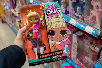 Person holding a boxed L.O.L. Surprise! OMG Speedster doll in a toy aisle.