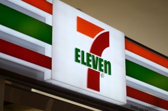 Close-up of a 7-Eleven storefront sign featuring its iconic red, orange and green tricolor design.