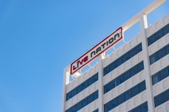Exterior of a modern office building with a Live Nation sign on the rooftop, set against a clear blue sky.