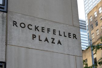 Rockefeller Plaza sign on the exterior of a building.