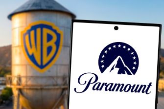 Warner Bros. logo on a water tower beside a laptop screen displaying the Paramount logo.
