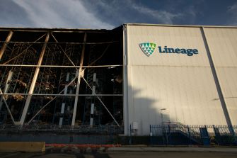 Charred left side of a Lineage warehouse exterior in Boyle Heights, with the Lineage sign visible on the right.
