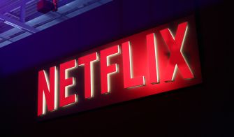 Netflix logo lit in red neon against a dark background.