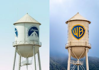 Two water towers branded with the Paramount and Warner Bros. Discovery logos stand side by side.