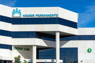 Kaiser Permanente medical office building with an urgent care entrance and blue sky above.