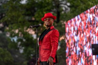 Ne-Yo (Shaffer Chimere Smith) performing on stage in a red suit and red hat.