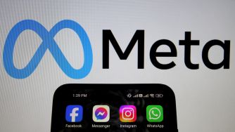 Meta logo beside a smartphone displaying app icons for Facebook, Messenger, Instagram and WhatsApp.