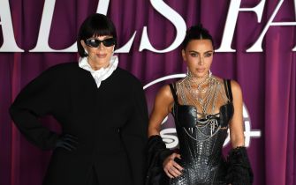 Kim Kardashian and Kris Jenner stand together in glamorous outfits at a public event.