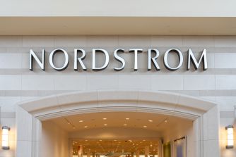 Nordstrom storefront entrance with a large illuminated sign bearing the brand name above the doorway.