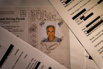 Close-up of scattered government documents and a photo ID card showing a man’s portrait among other papers.
