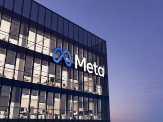 Exterior view of a Meta office building at dusk with the Meta logo visible on the glass facade.