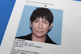 Portrait-style identification photo of a woman with short dark hair against a light blue background, with the subject's name and other details visible on a document at the bottom.