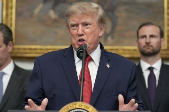 Donald Trump speaks at a podium with a microphone during a formal event.