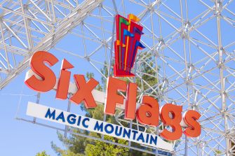 Six Flags Magic Mountain entrance sign with the colorful logo mounted beneath a steel lattice framework.