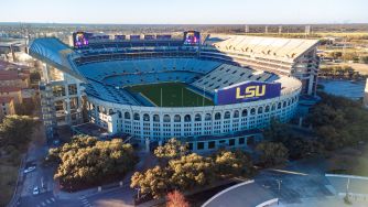 Aerial view of LSU's Tiger Stadium in Baton Rouge, with the football field visible inside and the LSU logo on the exterior.
