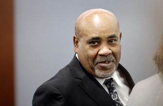 Duane “Keffe D” Davis, a Black man with a shaved head and goatee wearing a dark suit, looks to the left in a courtroom setting.