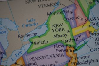 Map fragment showing Lake Ontario along the U.S.–Canada border with nearby New York cities Rochester and Buffalo and the Canadian province of Ontario.