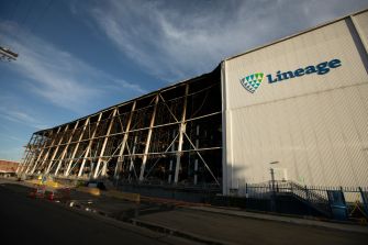 Fire-damaged Lineage cold-storage warehouse with its charred exterior exposed beneath the intact Lineage logo.