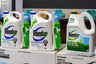 Roundup weed killer bottles and refill containers displayed on a retail store shelf.