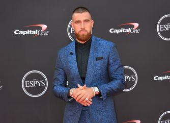 Travis Kelce poses in a blue patterned suit at an ESPYS and Capital One event.