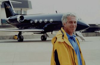 Jeffrey Epstein stands beside a private jet on an airport tarmac.