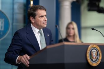 Attorney General Todd Blanche speaks at a podium bearing the U.S. Department of Justice seal.