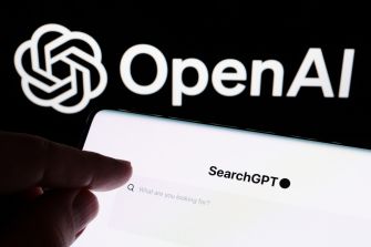 Hand pointing at a laptop screen displaying the OpenAI logo and SearchGPT interface.