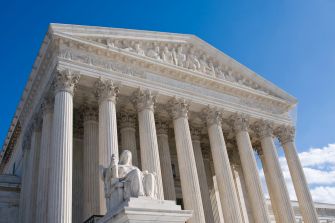 The U.S. Supreme Court building stands against a blue sky.