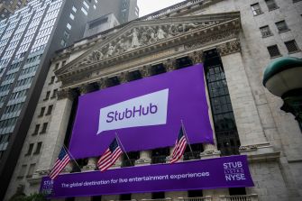 StubHub banner displayed on the New York Stock Exchange building, with American flags and surrounding skyscrapers.