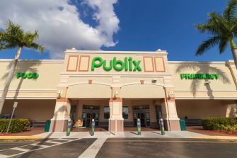 Publix supermarket storefront with the green Publix logo and pharmacy sign visible above the entrance.