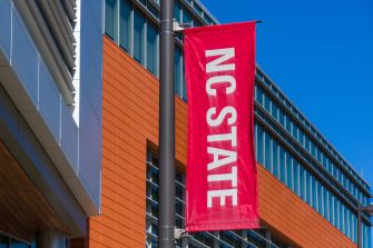 North Carolina State University building with a red NC STATE banner outside.