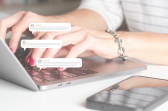 Hands typing on a laptop with anonymous website comment overlays, a tablet and smartphone nearby.