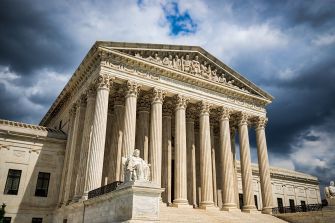 U.S. Supreme Court building under a cloudy sky.