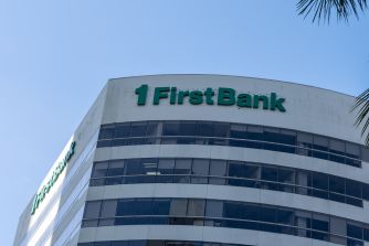 FirstBank office building with the bank’s logo displayed on its curved facade.