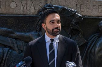 New York City Mayor Zohran Mamdani speaks to reporters at a podium.