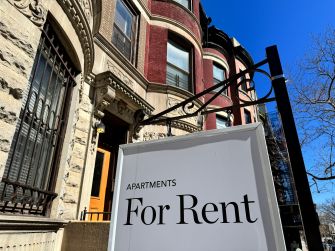 “For Rent” sign outside an apartment building.
