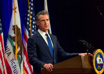 California Gov. Gavin Newsom speaks at a podium in front of California and U.S. flags during the child marriage ban bill signing.