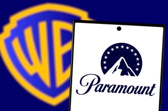 Paramount logo on a smartphone in front of a Warner Bros. shield logo.