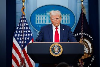 President Donald Trump speaks at a White House podium flanked by U.S. flags.