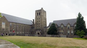 Cornell University campus building with a stone tower and surrounding lawn.