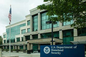U.S. Department of Homeland Security building with an American flag and agency sign.