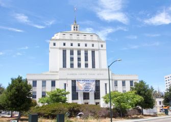 Alameda County Superior Court building in Oakland, California, under a blue sky.
