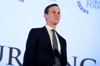 Jared Kushner stands in a suit before a stage backdrop displaying the Foreign Policy logo.
