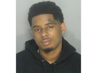 Pooh Shiesty, whose legal name is Lontrell Williams Jr., wears a black hoodie in a portrait.