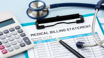 Medical billing statement with a stethoscope and calculator, representing medical debt relief.