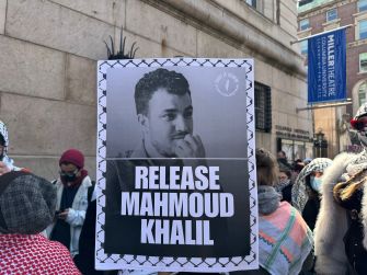 Protesters hold a “Release Mahmoud Khalil” sign featuring his portrait outside Columbia University.